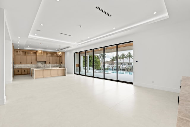 unfurnished living room with a raised ceiling