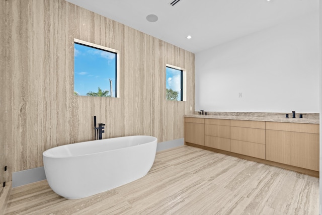 bathroom featuring a tub to relax in and sink