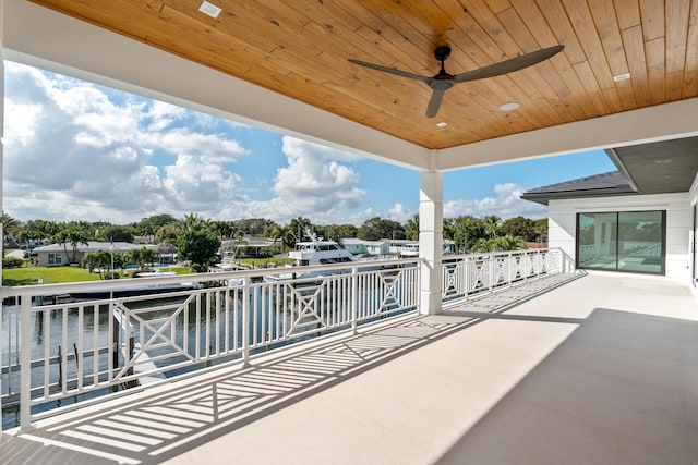 view of patio featuring a balcony, a water view, and ceiling fan