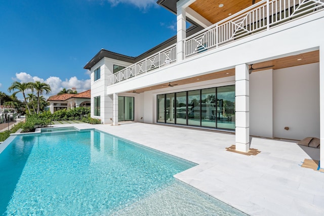 view of swimming pool with ceiling fan and a patio area