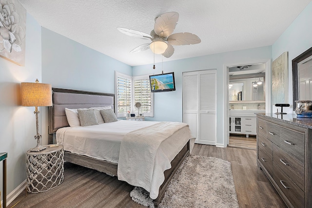 bedroom with ensuite bath, ceiling fan, dark hardwood / wood-style floors, a textured ceiling, and a closet