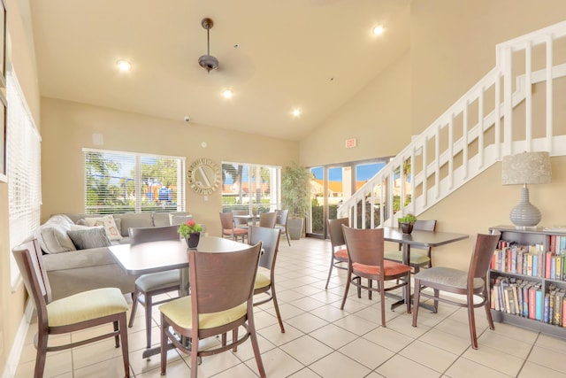 dining space featuring light tile patterned flooring and high vaulted ceiling