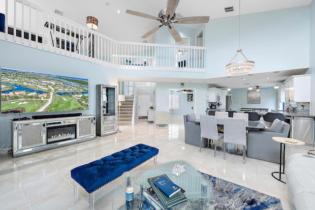 living room featuring ceiling fan with notable chandelier and light tile patterned floors