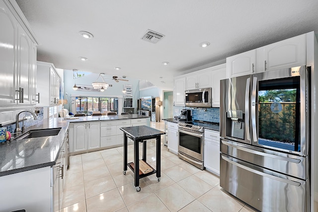 kitchen with sink, stainless steel appliances, kitchen peninsula, and white cabinets