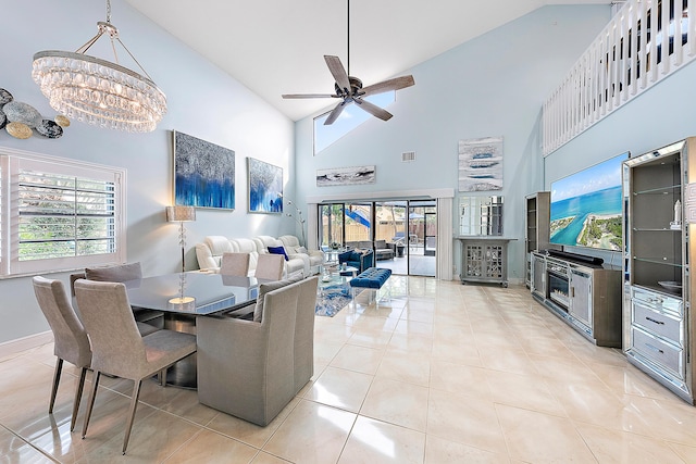 tiled dining area with ceiling fan with notable chandelier and a high ceiling