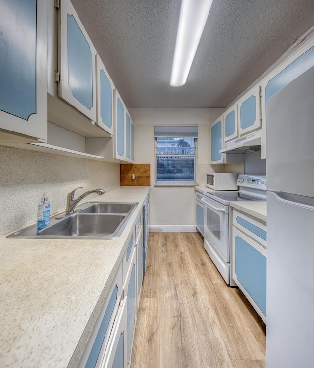 1 S Lakeside Dr Unit A2, Lake Worth Beach, FL 33460 - kitchen with white appliances, under cabinet range hood, a sink, light wood finished floors, and light countertops