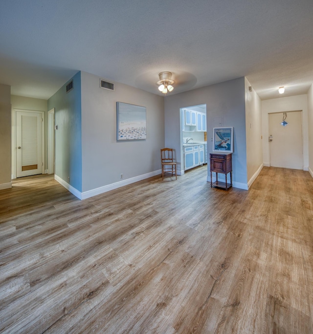 empty room featuring a textured ceiling and light wood-type flooring