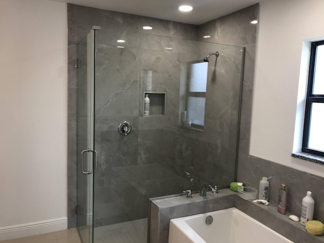 bathroom featuring shower with separate bathtub