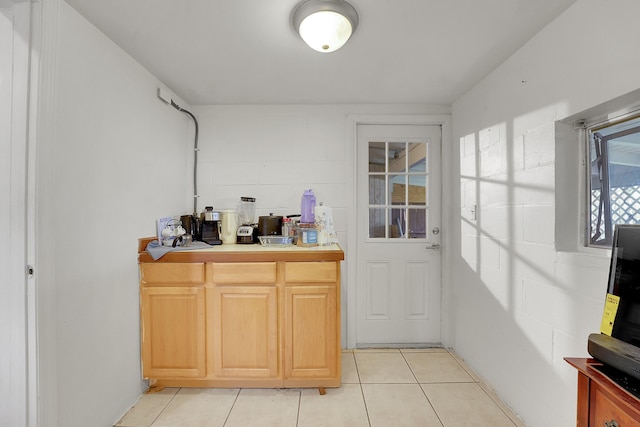 bar featuring light tile patterned floors and light brown cabinets