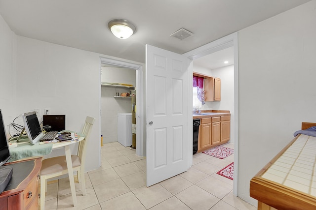 office space with washer / clothes dryer, sink, and light tile patterned floors