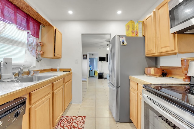 kitchen featuring light tile patterned floors, ceiling fan, stainless steel appliances, tile counters, and light brown cabinets