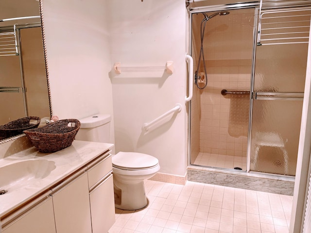 bathroom featuring vanity, toilet, tile patterned floors, and a shower with shower door