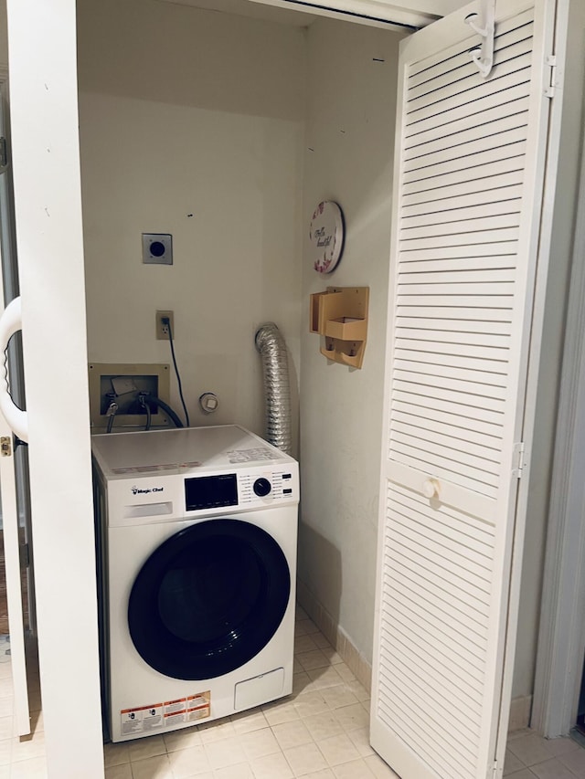 clothes washing area with washer / clothes dryer and light tile patterned floors