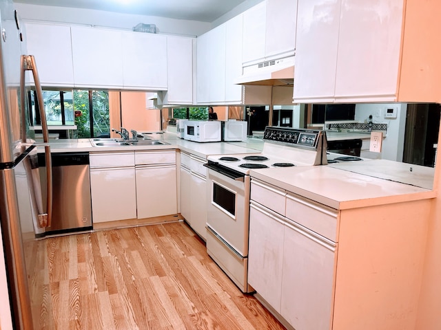 kitchen with white cabinetry, sink, white appliances, and light hardwood / wood-style floors