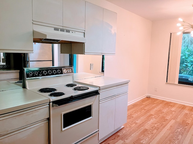 kitchen with white cabinetry, electric range, fridge, a notable chandelier, and light wood-type flooring