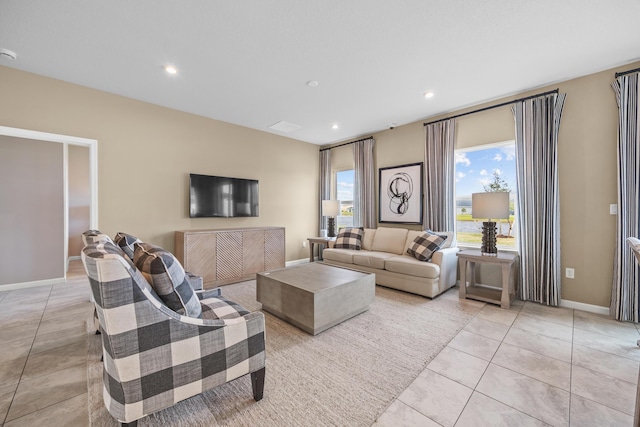 living room with a healthy amount of sunlight, light tile patterned floors, baseboards, and recessed lighting