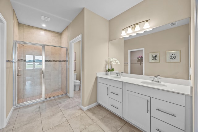 bathroom with visible vents, double vanity, a sink, and toilet