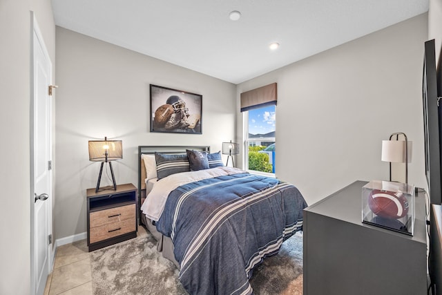 bedroom with baseboards and light tile patterned floors