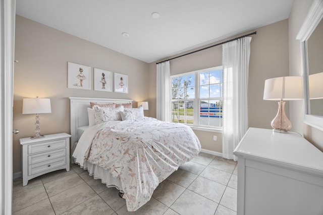 bedroom with light tile patterned flooring and baseboards