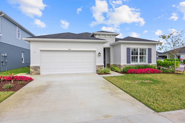 prairie-style house with concrete driveway, stone siding, an attached garage, a front yard, and stucco siding