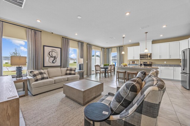 living room with light tile patterned flooring, visible vents, and recessed lighting