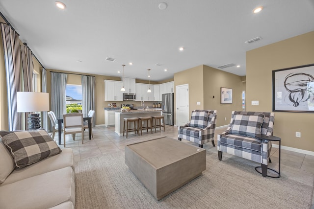 living area with baseboards, visible vents, and recessed lighting