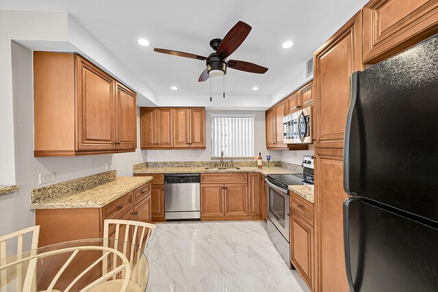 kitchen with marble finish floor, brown cabinets, stainless steel appliances, recessed lighting, and a sink