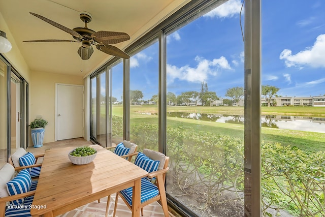 sunroom / solarium with a water view and ceiling fan