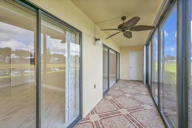 unfurnished sunroom featuring ceiling fan