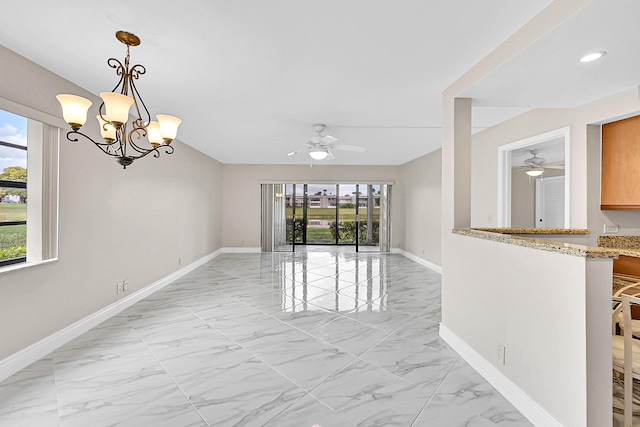 spare room with ceiling fan with notable chandelier, marble finish floor, and baseboards