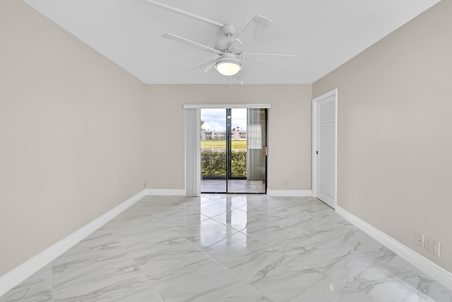 unfurnished room featuring a ceiling fan, marble finish floor, and baseboards