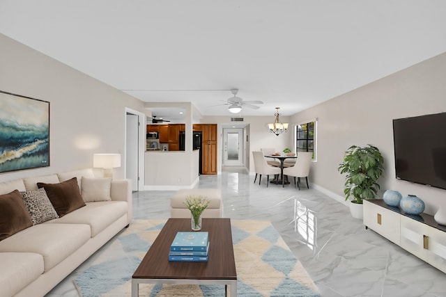 living area featuring ceiling fan with notable chandelier, marble finish floor, visible vents, and baseboards