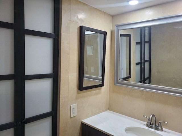 bathroom with vanity and tile walls