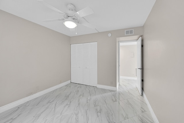 unfurnished bedroom with a closet, visible vents, marble finish floor, and baseboards