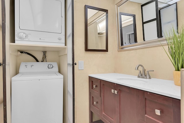 laundry area featuring stacked washer and dryer, laundry area, and a sink