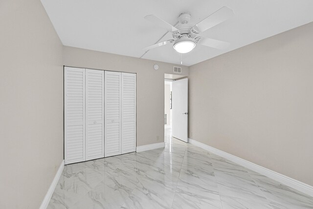 unfurnished bedroom featuring marble finish floor, a closet, visible vents, and baseboards