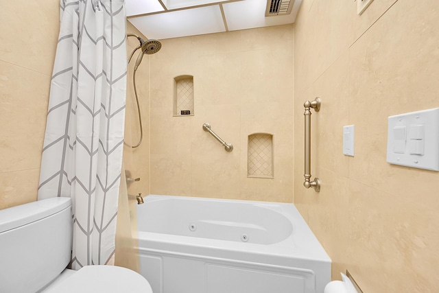 bathroom with shower / bath combo, visible vents, tile walls, and toilet