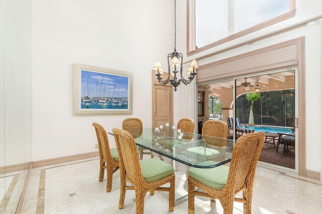 dining space with an inviting chandelier and a high ceiling