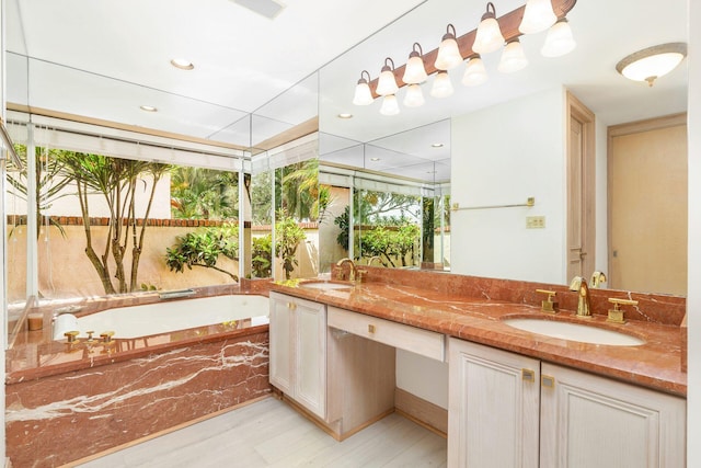 bathroom featuring a relaxing tiled tub, vanity, and wood-type flooring