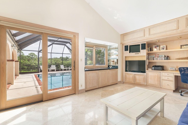 interior space with built in desk and high vaulted ceiling