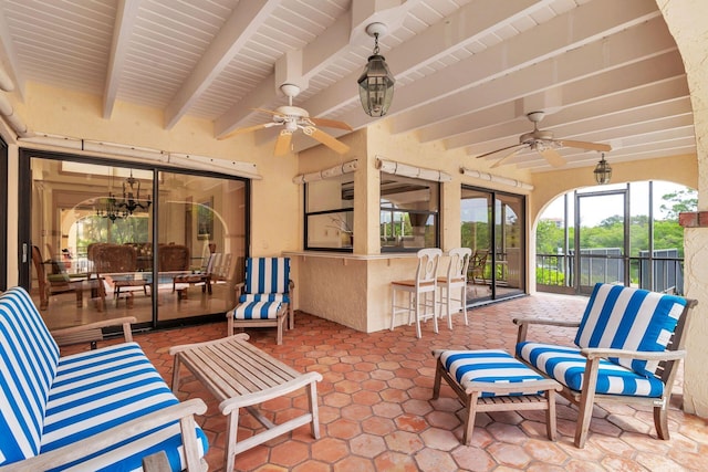 view of patio with ceiling fan and a bar