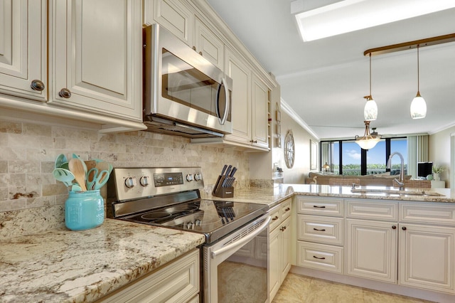 kitchen with a sink, stainless steel appliances, light stone countertops, and backsplash