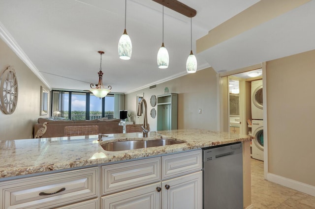 kitchen featuring crown molding, open floor plan, stacked washer and dryer, stainless steel dishwasher, and a sink