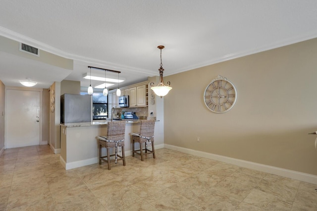 kitchen with crown molding, a breakfast bar, appliances with stainless steel finishes, light stone countertops, and kitchen peninsula