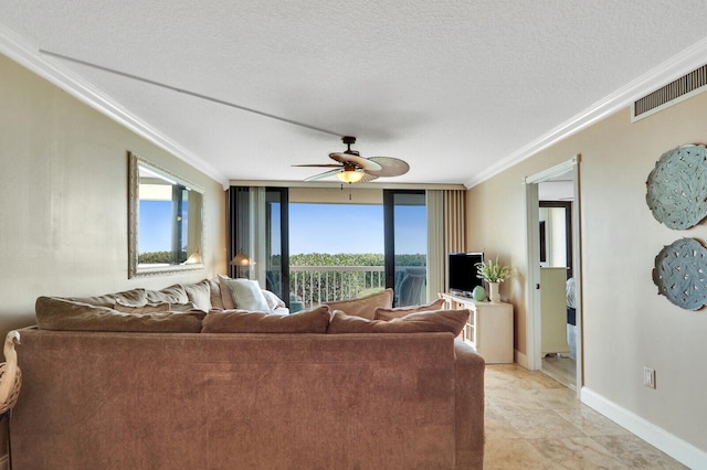 living area with visible vents, a textured ceiling, crown molding, baseboards, and ceiling fan