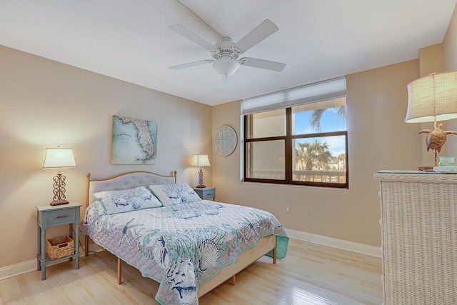 bedroom with a ceiling fan, wood finished floors, and baseboards