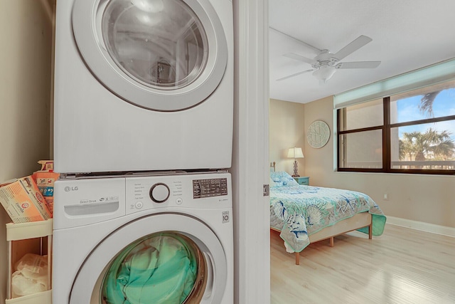 laundry room featuring stacked washer and clothes dryer, ceiling fan, and light wood-type flooring