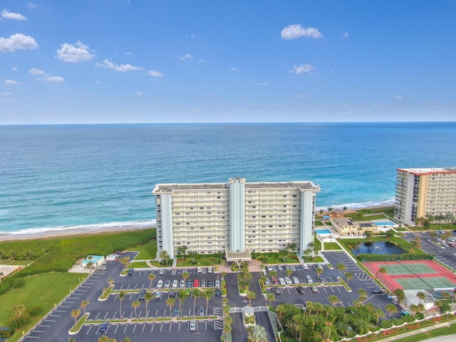 drone / aerial view featuring a beach view and a water view