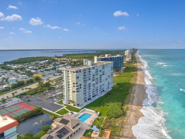 birds eye view of property with a water view and a beach view