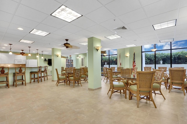 dining area with expansive windows and a paneled ceiling